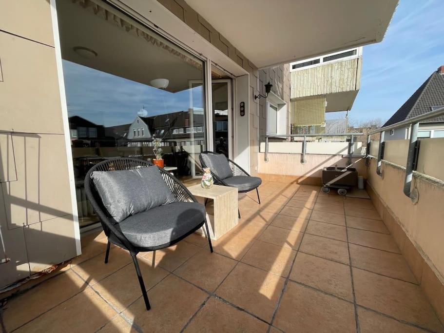 eine Terrasse mit zwei Stühlen und einem Tisch auf einem Balkon in der Unterkunft Relax Center Suite in Essen