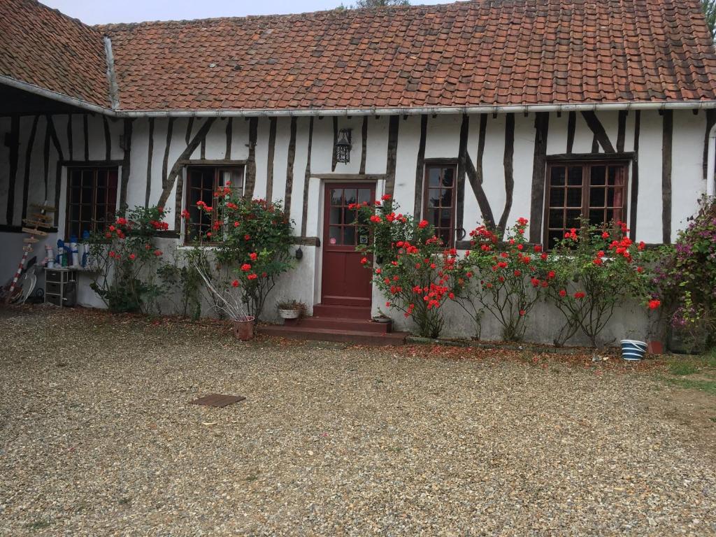 a white house with red flowers in front of it at Baie de Somme Villa gros Becs in Dominois