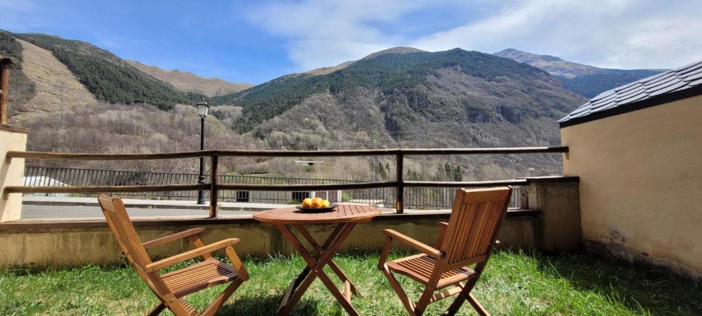 a table and two chairs on a balcony with mountains at Vall Fosca Apartment "Majue" in Torre de Capdella