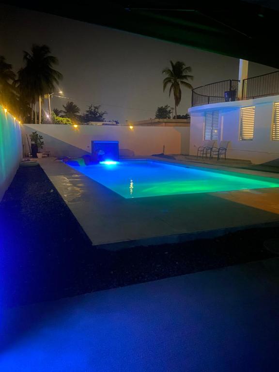 a swimming pool lit up at night with blue lights at Whole Apartment/Private Pool/Netflix/Wifi in Carolina
