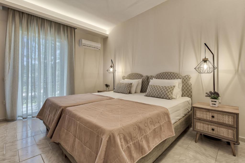 een slaapkamer met een groot bed en een groot raam bij Sofia - Yiota Studios & Apartments in Tsilivi