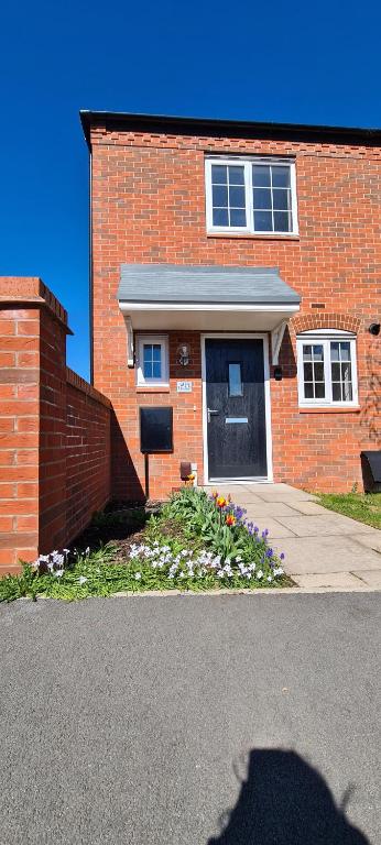um edifício de tijolos com uma porta e flores em frente em Wishart Drive 