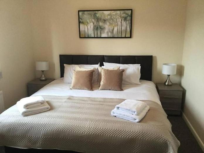 sypialnia z dużym łóżkiem z ręcznikami w obiekcie Park Cottage w mieście Scunthorpe