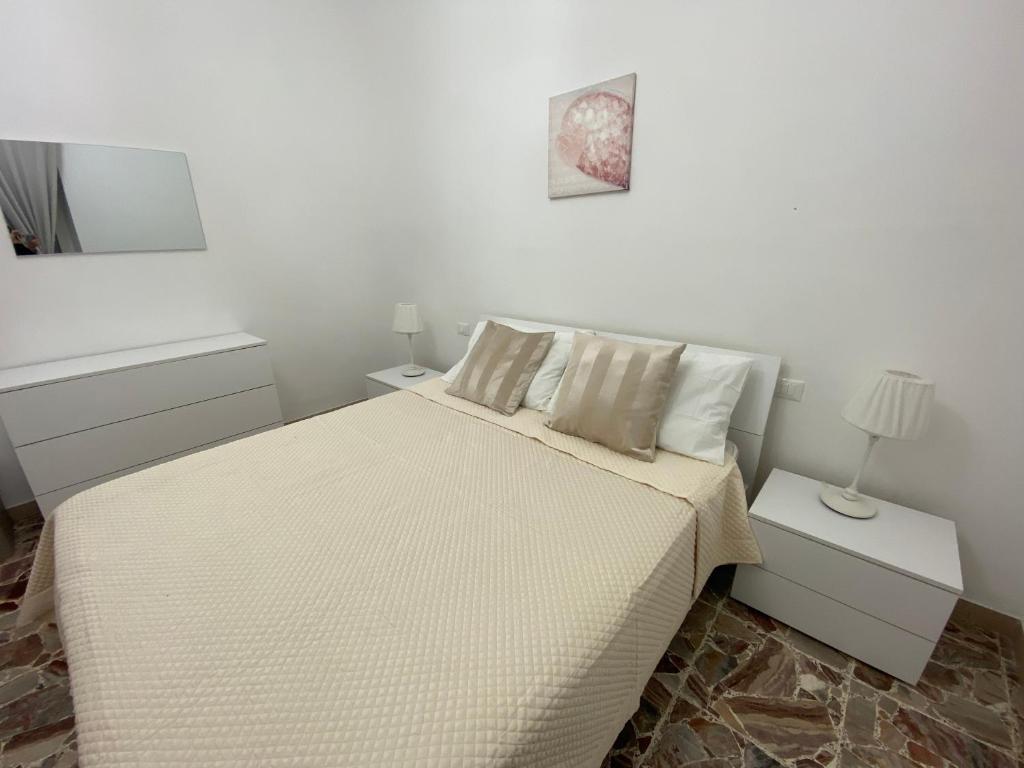 una camera bianca con un letto e due comodini di Casa Matilde & Aurora con giardino e posto auto privato a Sirolo