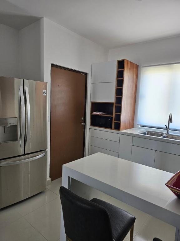 a kitchen with a stainless steel refrigerator and a counter at Condominio Palomino en Viñedos del Mar Ensenada privada San Antonio in Ensenada