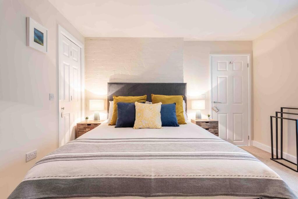 une chambre avec un grand lit avec des oreillers jaunes et bleus dans l'établissement The Little Loft St Ives, à St Ives