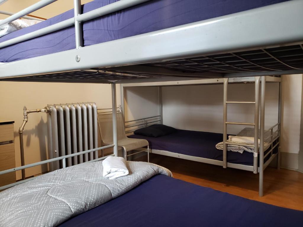 a bedroom with two bunk beds and a radiator at St. Clair Hotel Hostel in Vancouver