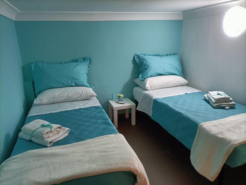 2 camas en una habitación con paredes azules en Napoli nel cuore, en Nápoles