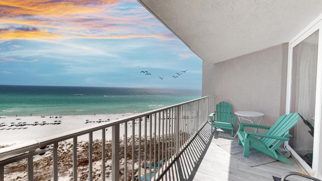 a balcony with two chairs and a view of the beach at Beachfront - Renovated - Gulf view Bedroom - FLPCB5 in Panama City Beach