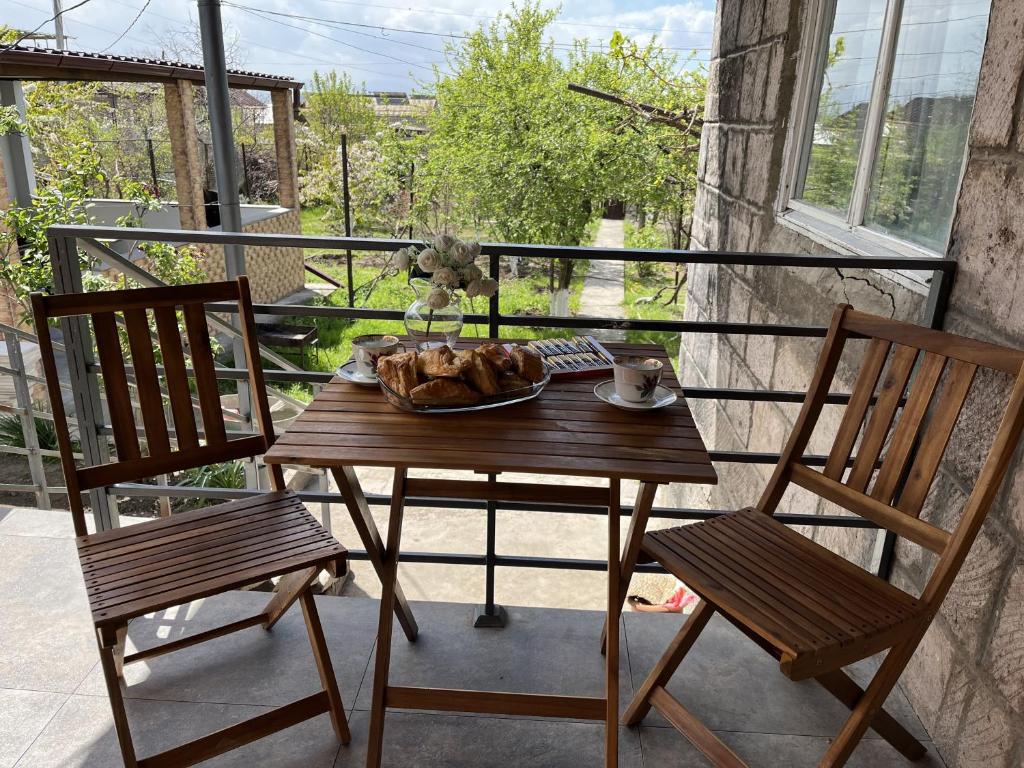 a table with a plate of food on a balcony at Дом в аренду - Kharberd House, долгосрочная и краткосрочная аренда in Yerevan
