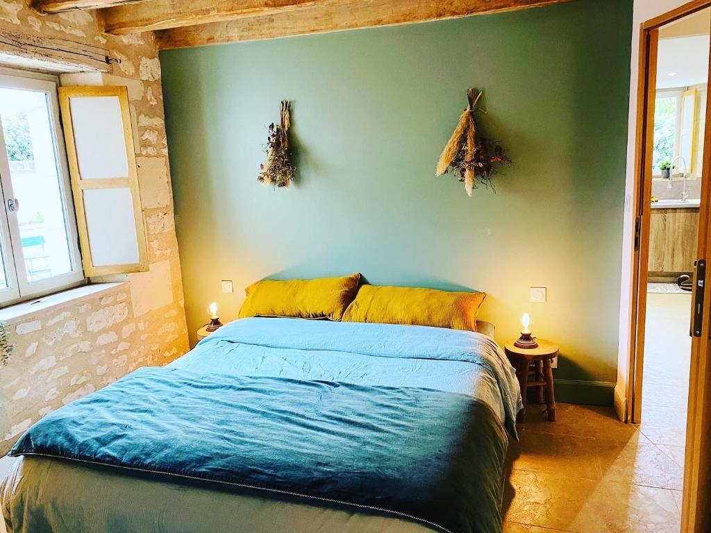 - une chambre avec un lit et un mur vert dans l'établissement Gîte verveine bain nordique jacuzzi l écrin de verdure chinon, à Ligré