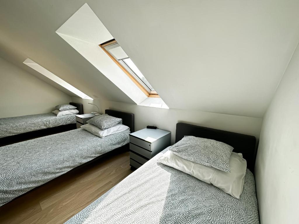 a attic bedroom with two beds and a skylight at Pokoje na Jasełkowej in Szczecin