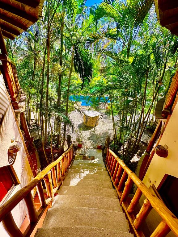 eine Treppe, die zu einem Resort mit Palmen führt in der Unterkunft Pacifica Surf Studios in Playa Santa Teresa