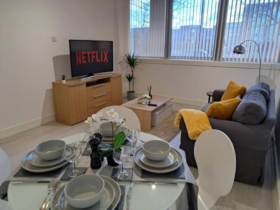 a living room with a table and a couch at Luxury 2 Bedroom Charter House in Milton Keynes