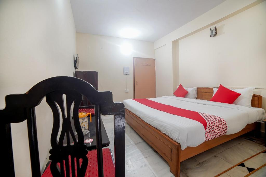 een slaapkamer met een bed met rode kussens bij Flagship Hotel Arsh in Bhowāli