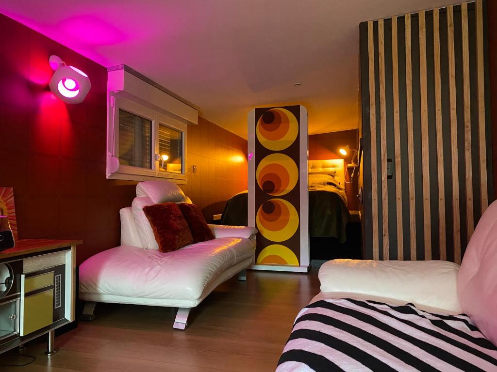 a room with two beds and pink lights at Love room - love Abella box, location adulte in Saint-Étienne-au-Mont
