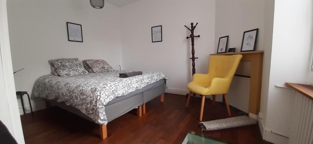 - une chambre avec un lit et une chaise jaune dans l'établissement Ker Karantez, à Rennes