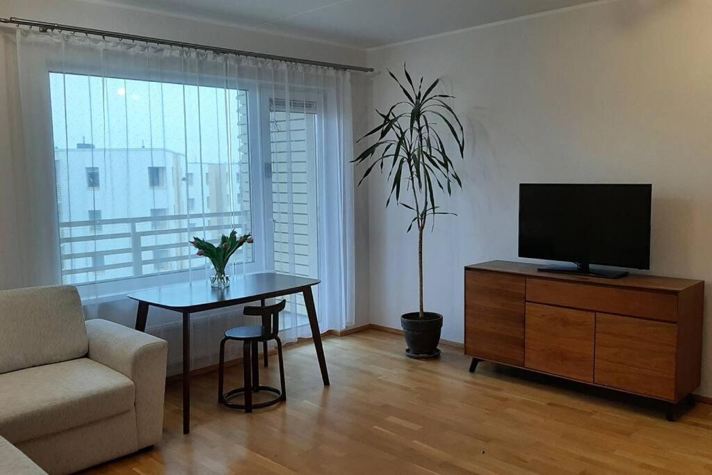 sala de estar con TV, mesa y silla en Puhas 2 toaline Kakumäe korter en Tallin
