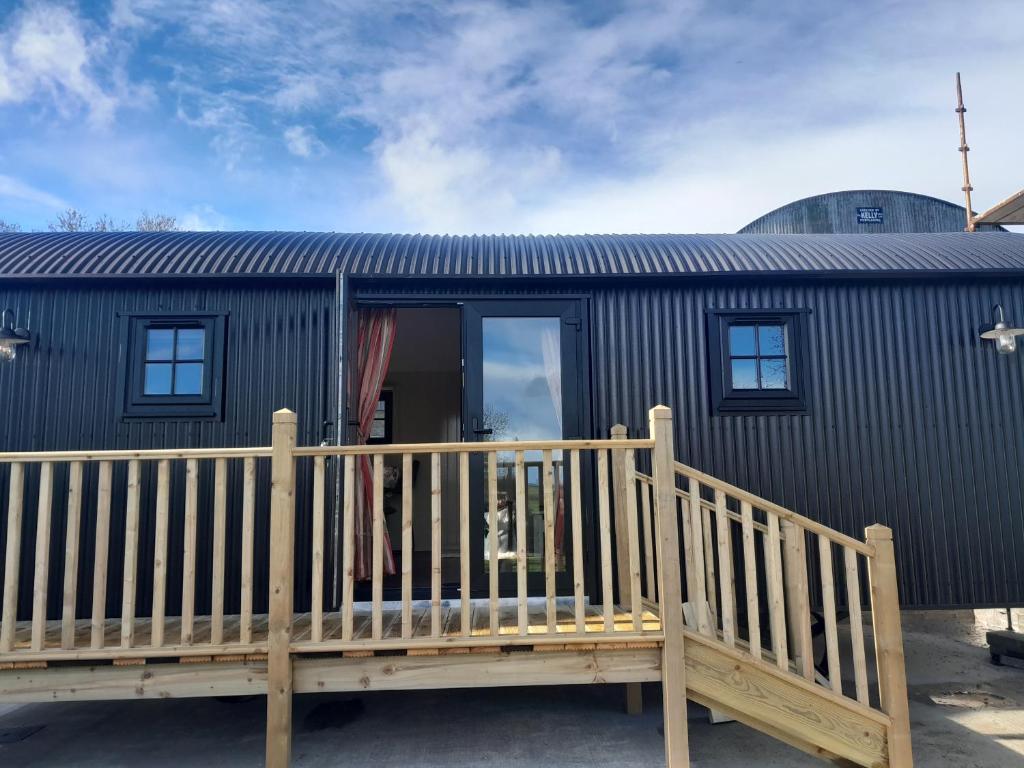 una casa con una terrazza in legno e un edificio di Rathgillen Cabin a Nobber