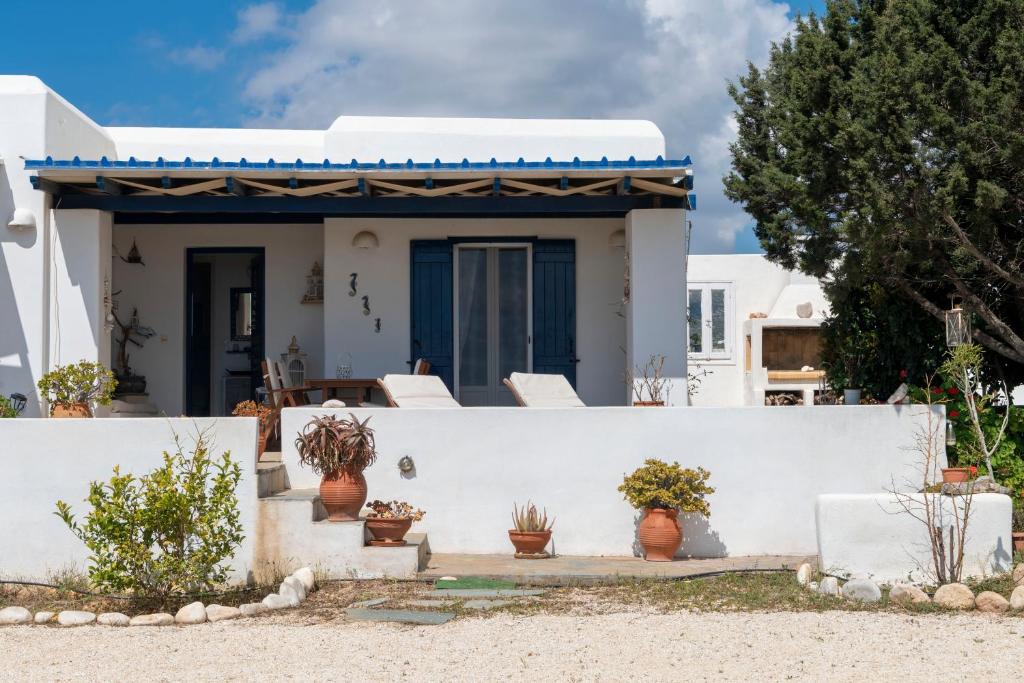 una casa bianca con pareti bianche e sedie bianche di Cycladic home in Paros a Kampos Paros