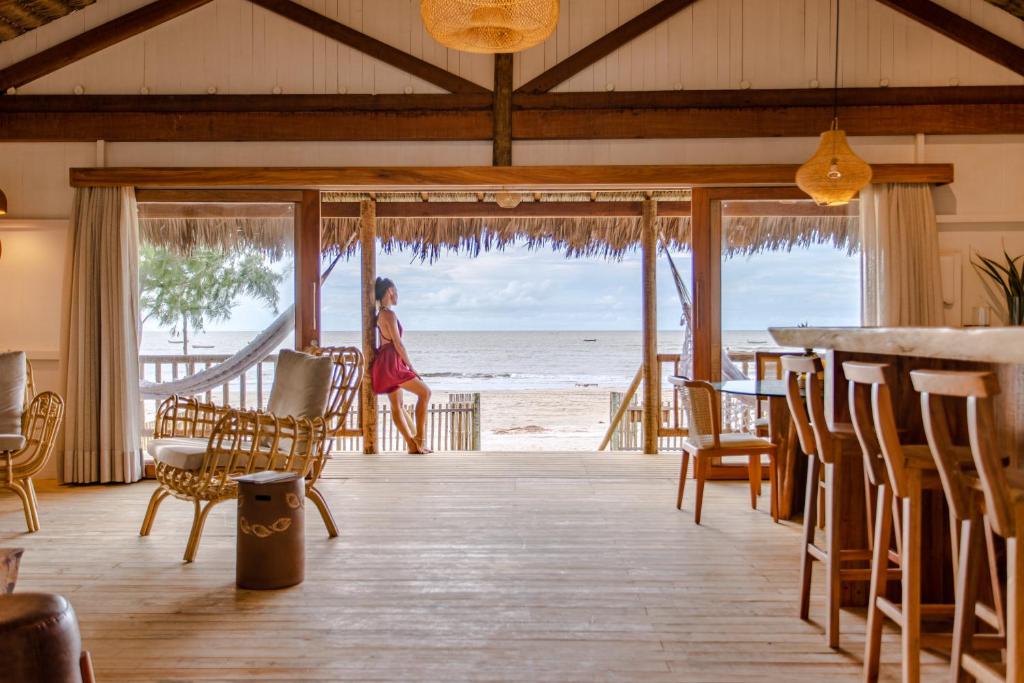 a woman walking through a room with a view of the beach at CASA na PRAIA DA BARRINHA Frente Mar in Barrinha