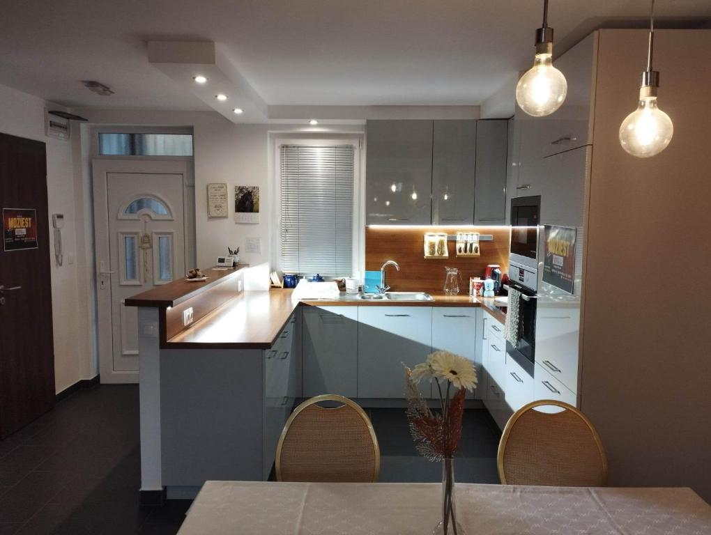 a kitchen with white cabinets and a table and chairs at Italia House in Fót