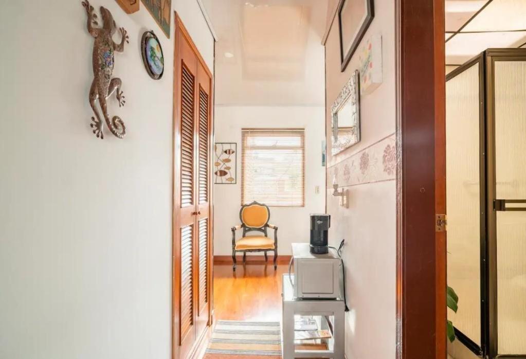 a hallway with a table and a chair in a room at Excelente cómoda habitación privada cerca parque Simon Bolivar in Bogotá