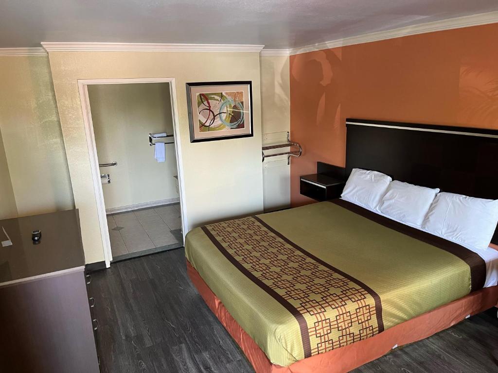 a hotel room with a bed and a bathroom at Rivera Inn & Suites Motel in Pico Rivera