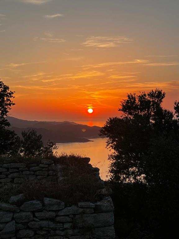 a sunset with the sun setting over the water at Résidence CATALINA in Saint-Florent