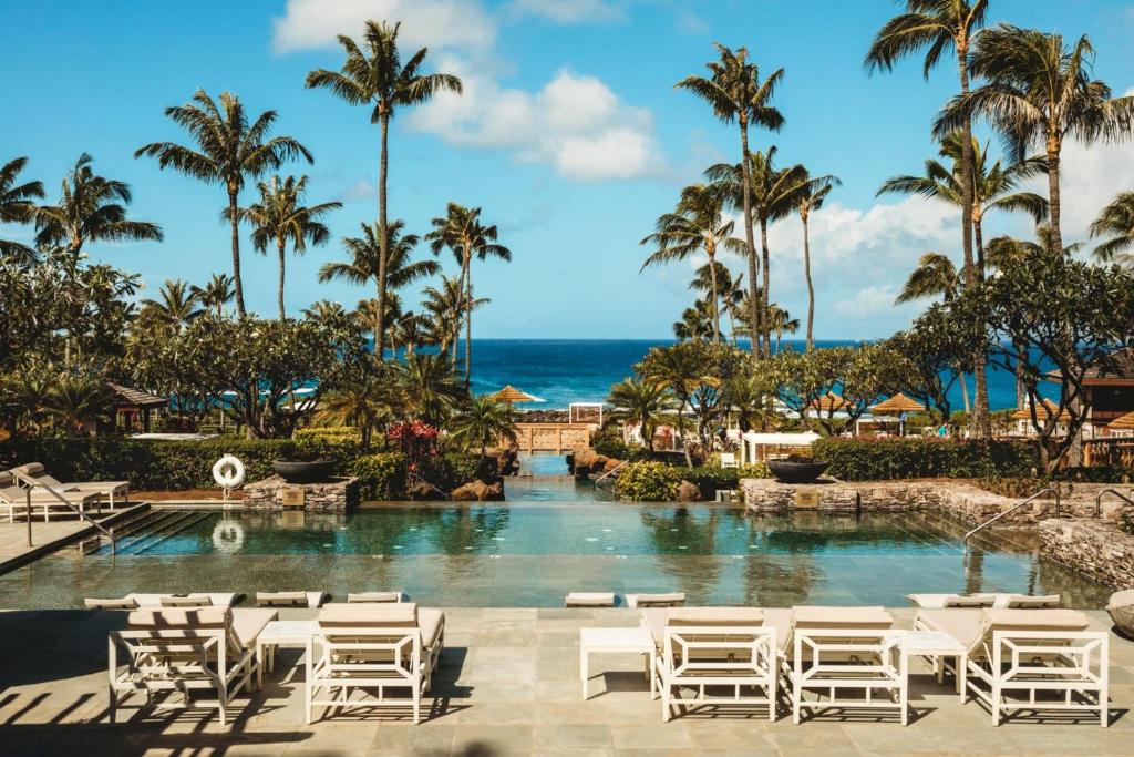a pool at a resort with white chairs and palm trees at K B M Resorts Montage Residence Pama 2206 Stunning Groundfloor 3 bed Perfect for Families Easy pool access LOccitane Amenities in Kapalua
