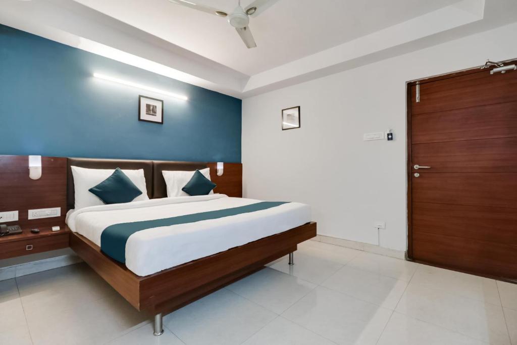 a bedroom with a large bed with a blue wall at Hotel Stay Inn Maharani Peta in Alipur