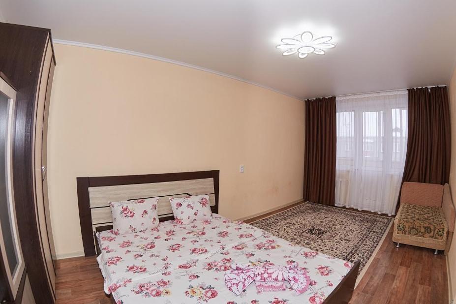 a bedroom with a large bed with pink sheets at Венеция in Petropavlovsk