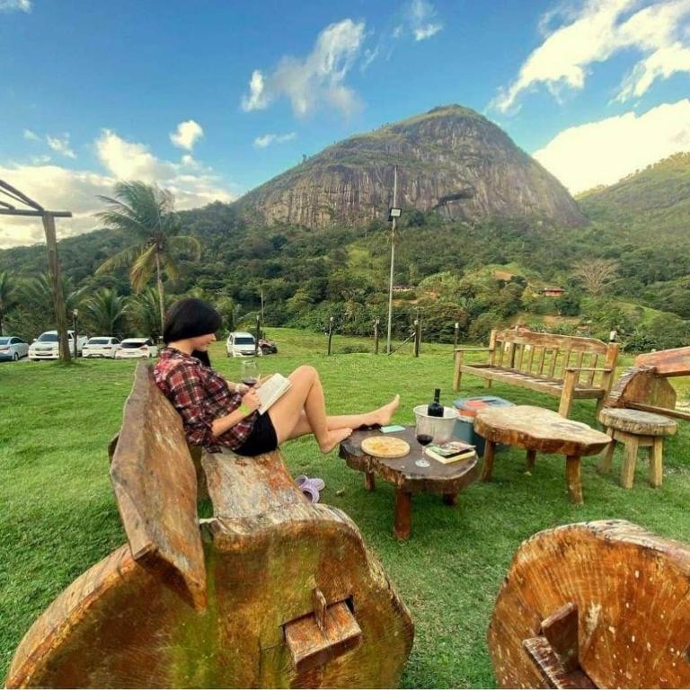 a woman sitting on a bench looking at a mountain at Flat completo do Rodeadouro in Bonito