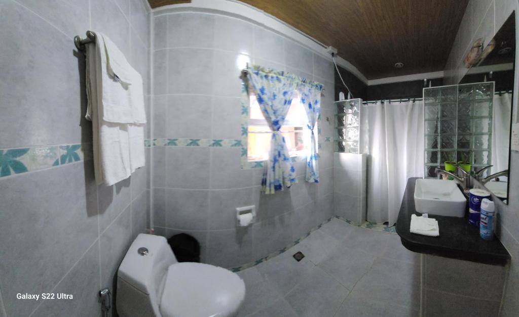 baño con aseo y lavabo y ventana en CHUE&LARRY'S BEACHSIDE HOMESTAY, en Libagon