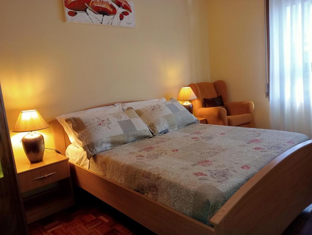 a small bedroom with a bed and a chair at Apartamento Alvares Cabral in Vila Nova de Gaia