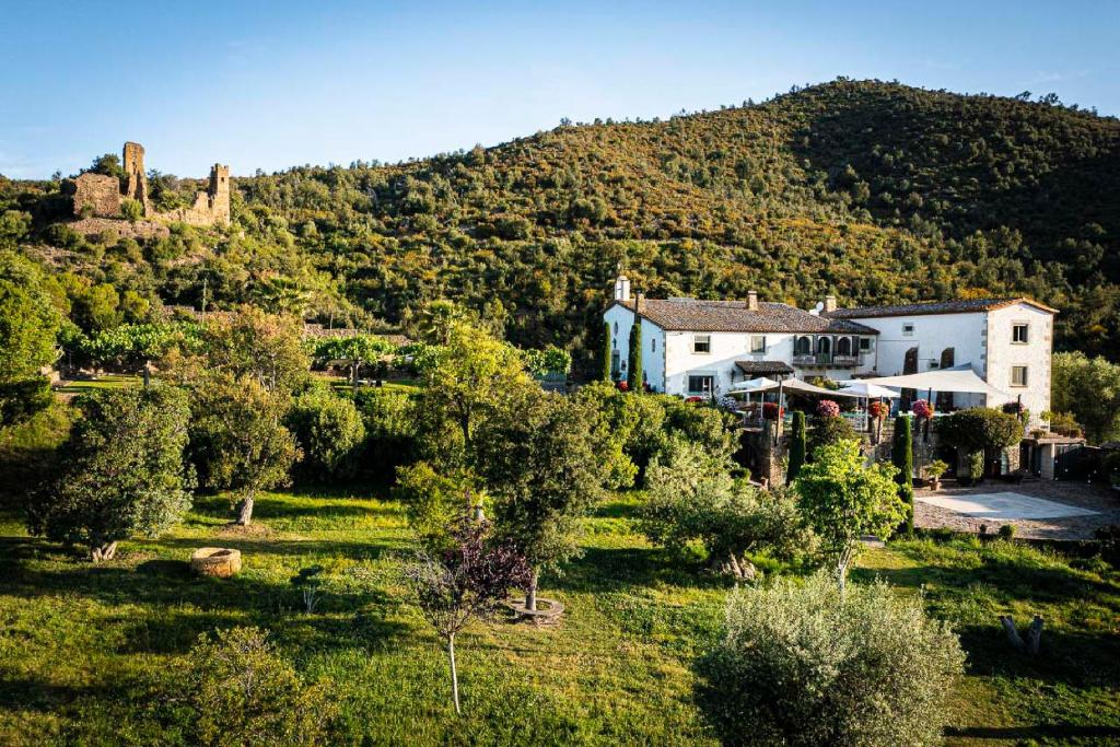 a house in a field with a mountain in the background at Finca Bell-Lloc in Palamós