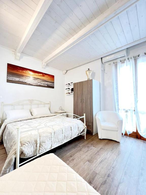 1 dormitorio blanco con 1 cama y 1 silla en Il Girasole, en Ostuni