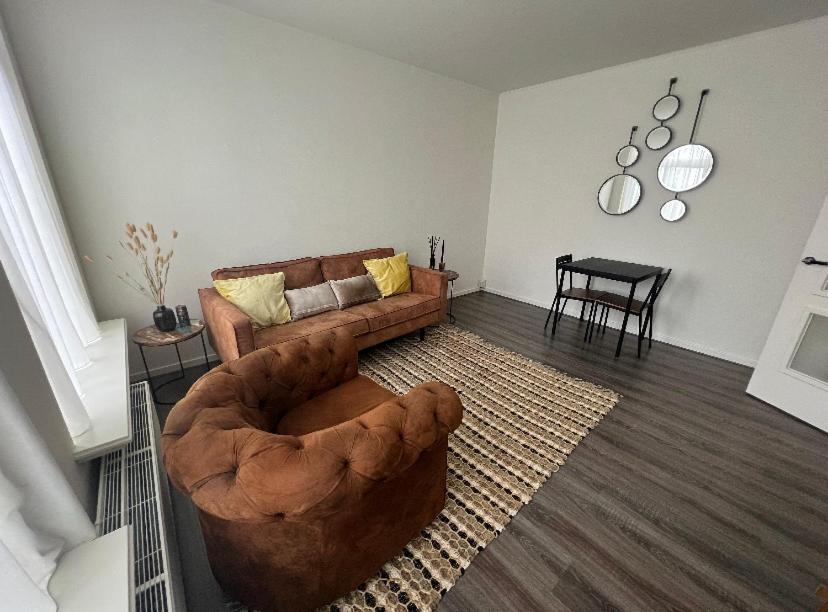 uma sala de estar com um sofá castanho e uma mesa em Appartement City Enschede (free private parking) em Enschede