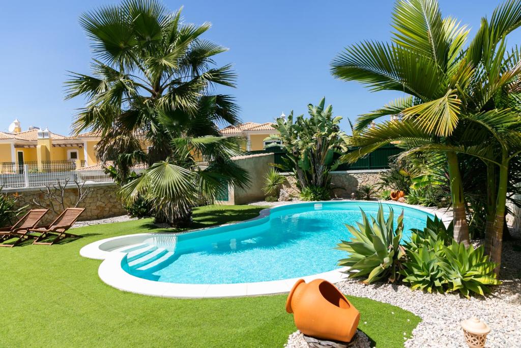 - une piscine dans une cour avec des palmiers dans l'établissement Dream villa with private pool, à Algoz