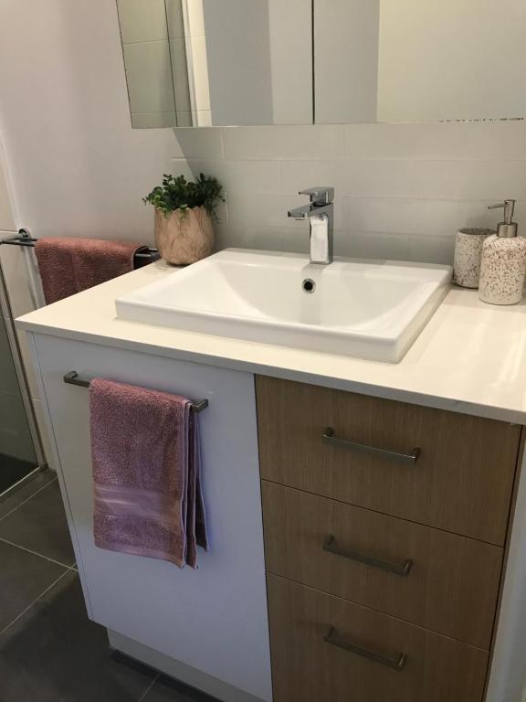 y baño con lavabo blanco y espejo. en Unit 1 - Manly Boutique Apartments en Brisbane