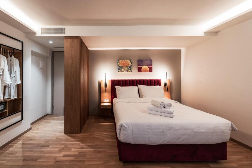 a bedroom with a large bed with towels on it at Urban Frame Acropolis in Athens