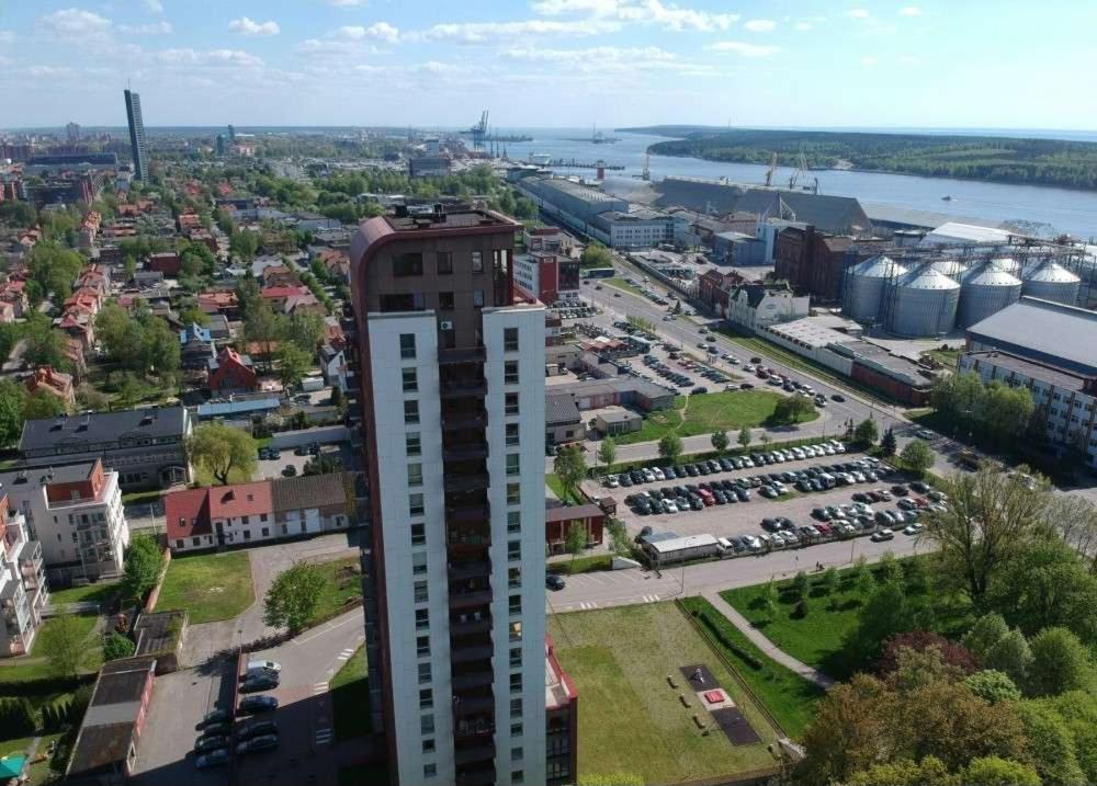 um edifício alto numa cidade com estacionamento em "Kurhause" namai em Klaipėda