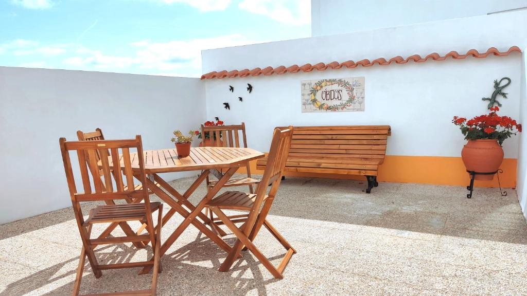 una mesa, sillas y un banco en un patio en Mood Lodging - Óbidos en Óbidos