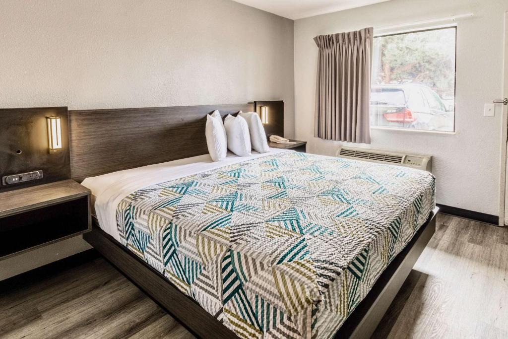 um quarto de hotel com uma cama com uma colcha em Motel 6-Carlsbad, CA - East Near LEGOLAND em Carlsbad