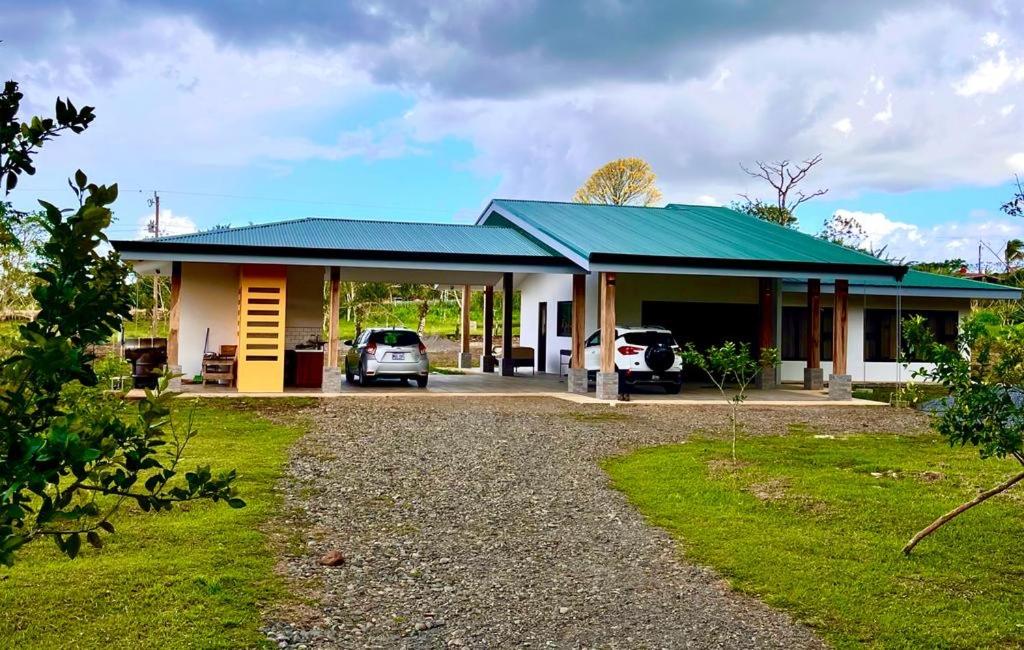 a house with two cars parked in front of it at Cortezas House in Aguas Zarcas