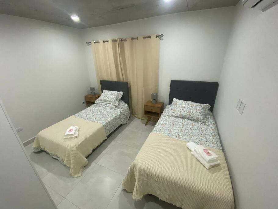 two beds in a room with a mirror at Belleza nueva! Zona Conmebol (606) in La Mercedes