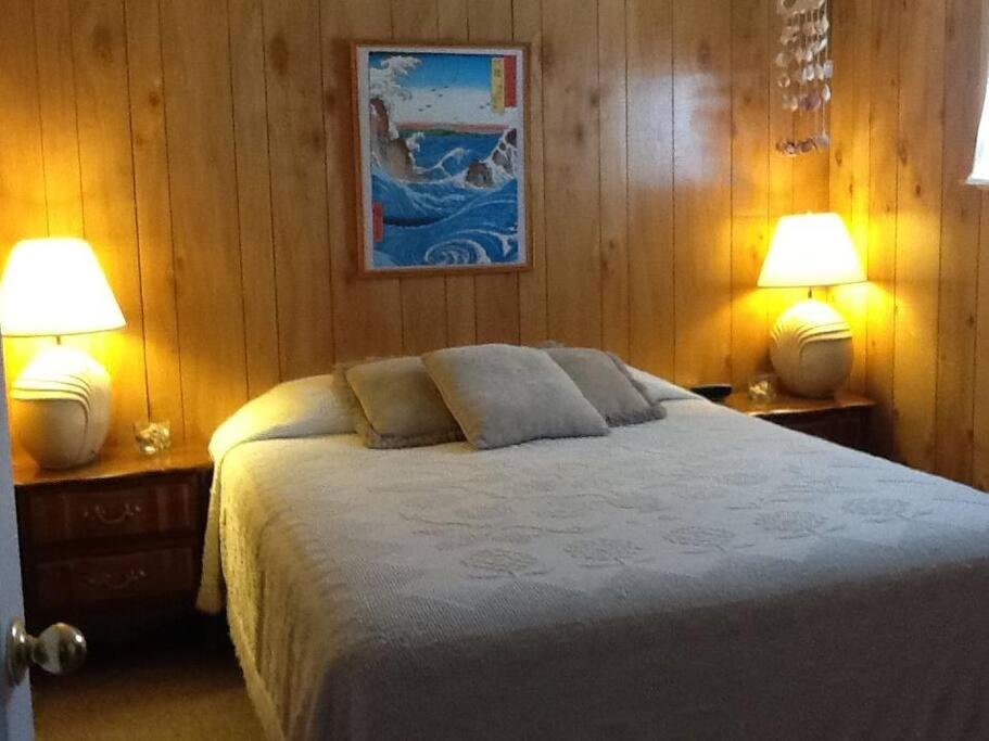 een slaapkamer met een groot bed met 2 lampen bij Suite Breeze Beach Vacation Rental - one bedroom apartment. in Morro Bay