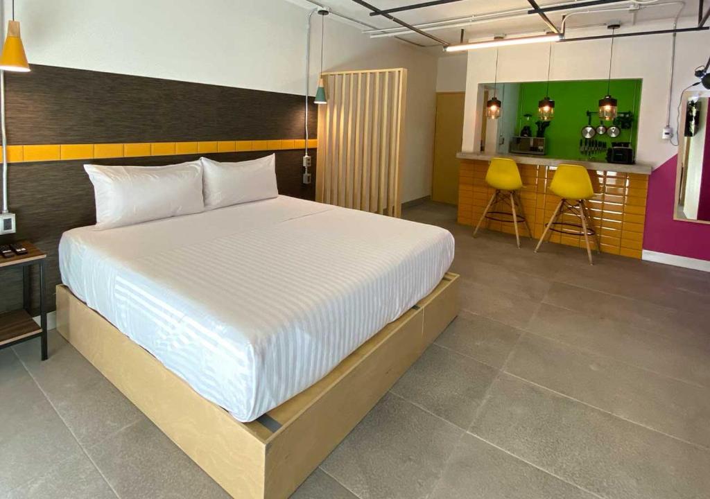 a bedroom with a large bed and a kitchen at The Host Business Suites at WTC in Mexico City