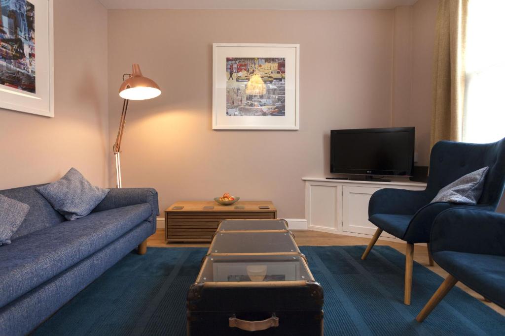 a living room with a couch and a tv at Highfield Grove in Nottingham