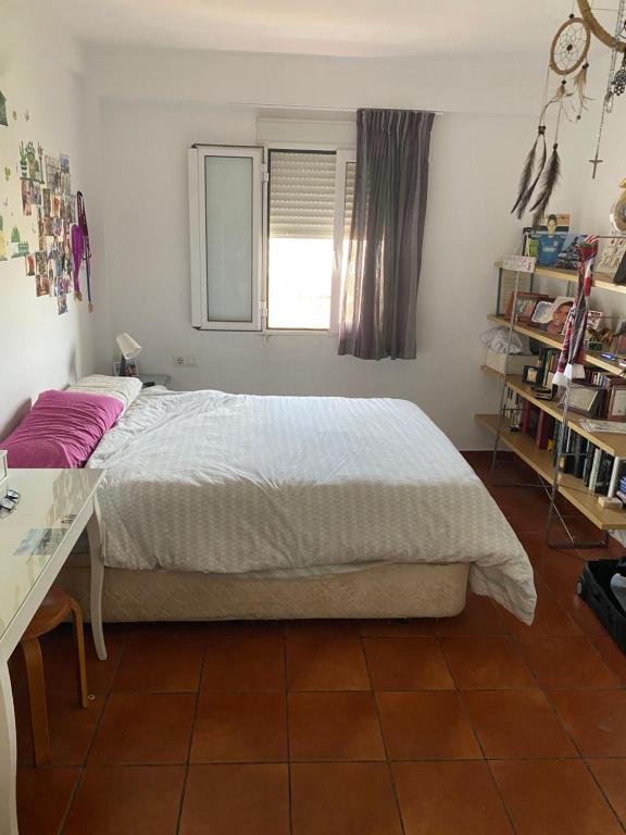 a bedroom with a large bed and a window at Habitación luminosa en piso compartido in Mairena del Aljarafe